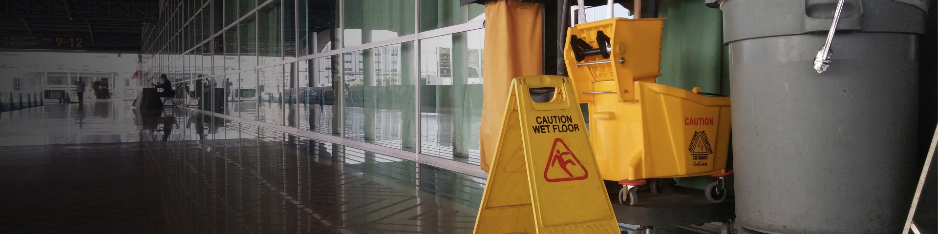 caution wet floor sign, mop bucket and garbage can at commercial space